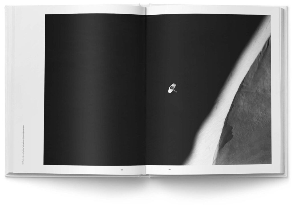Layout für „MOUNTAINS“ von Robert Bösch: Kunstvolle Schwarzweissaufnahme von Paragluider vor Gletscherwand mit besonderer Lichtstimmung. Das Bild kommt im zurückhaltenden Layout voll zur Geltung.
