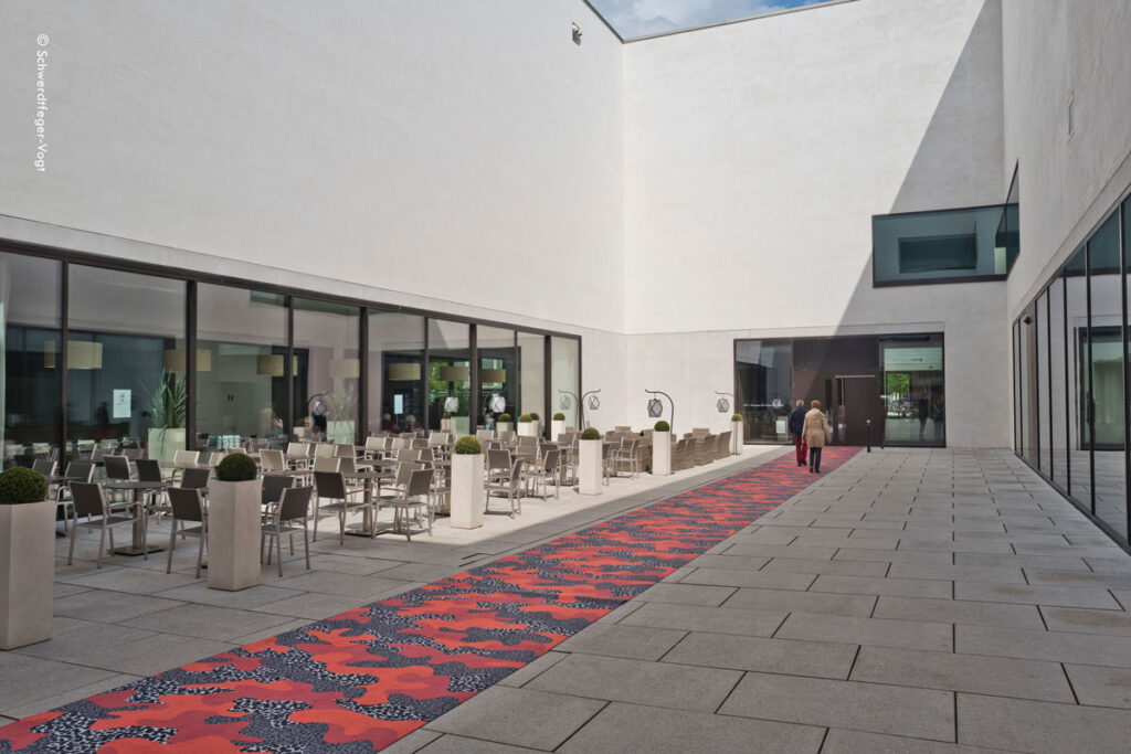 Eingang des LWL Museum für Kunst und Kultur Münster ausgelegt mit Camouflage-Teppich, passend zur Ausstellung