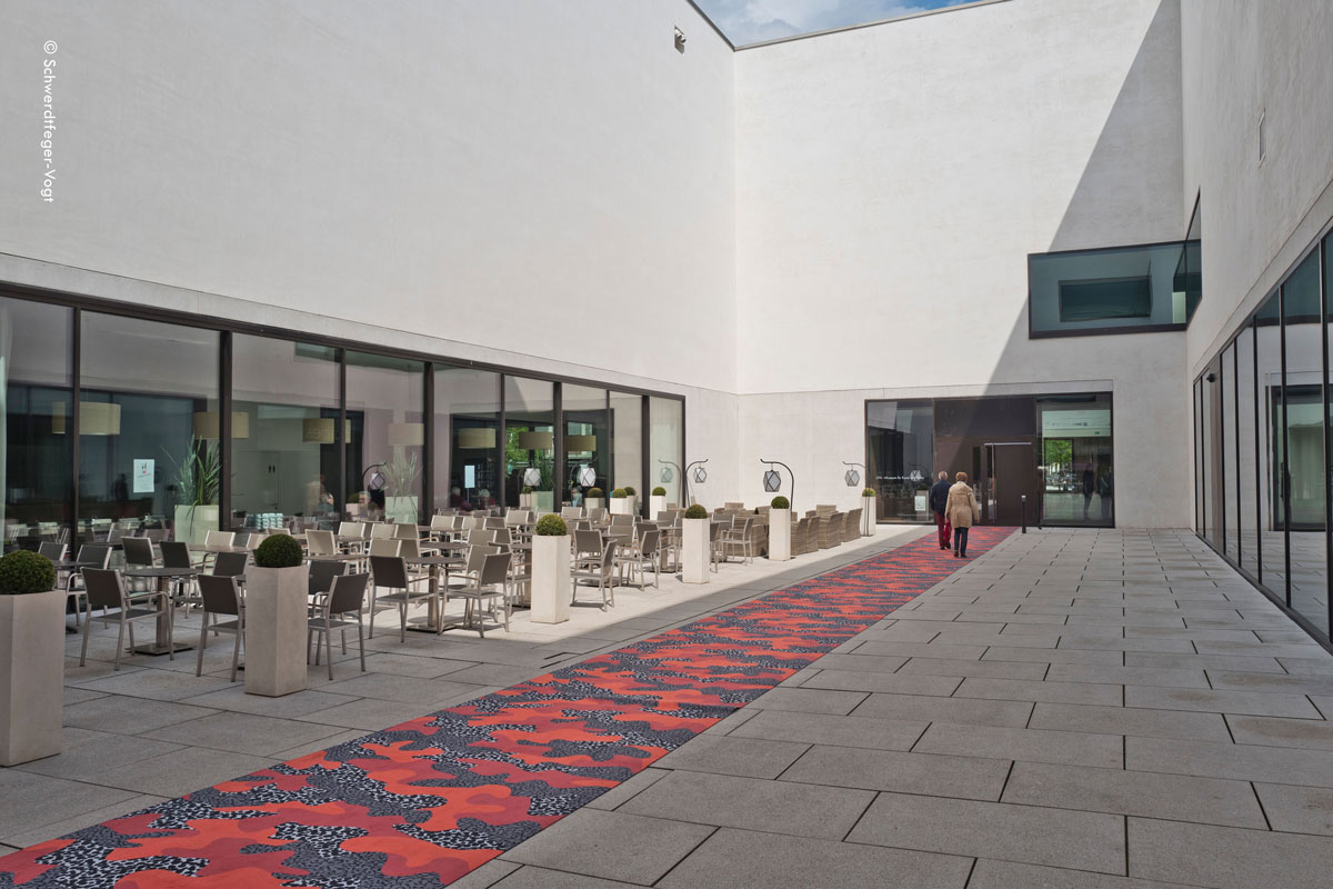 Eingang des LWL Museum für Kunst und Kultur Münster ausgelegt mit Camouflage-Teppich, passend zur Ausstellung